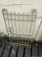 Full view of metal gate leaning against wall