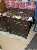 Front view of the washstand showing drawer, cabinet doors, finish wear