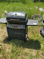 Front view of propane BBQ showing two side shelves and control panel