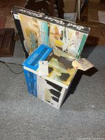 Both unopened product boxes: Bed Valet Deluxe bedside organizer and CreativeWare Adjustable Bed Riser System