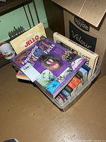 Plastic bin filled with assorted books placed on floor