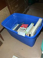 Blue plastic tote showing several books