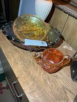 Large iridescent dish, orange spooner, partial view of additional dish