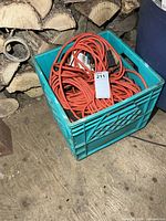 Milk crate containing coiled orange extension cords