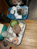 Two bins showing assorted glass vases, green bowl, milk glass pieces, clear butter dish, pottery items