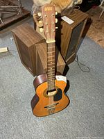 Full view of youth acoustic guitar standing upright