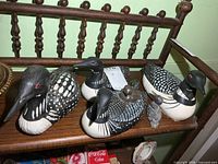 All five loon figurines displayed on shelf