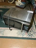 Stainless steel microwave showing full exterior and power cord