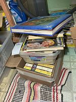 Stack showing "The Art of Nancy Drew" on top of assorted volumes in bin and box