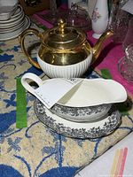 Teapot and gravy boat set on table showing overall appearance