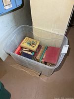 Plastic tote with assorted vintage hardcover books