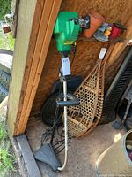 Full view of Weed Eater FeatherLite XT200 gas trimmer leaning in shed