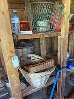 Group of baskets on shelving including wire basket, round wicker and rectangular wicker