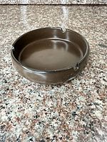 Oblique view of brown ceramic ashtray showing three rests and overall glaze