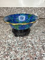 Bowl on wooden stand showing exterior pattern and scalloped rim