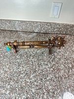 Full view of carved wooden mace resting on stand