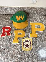 Hat and four chenille patches laid out on countertop