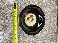 Top view showing floral design and tape measure indicating diameter