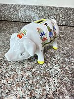 Left front view showing hand-painted Breton figure and floral decoration, yellow hoof accents