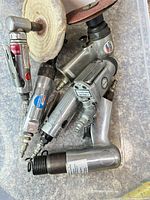 Bin containing multiple pneumatic tools, buffing pad and sanding disc