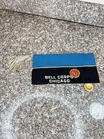 Cap side view showing Bell Corps Chicago text and round red-center pin
