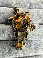Front view showing cabochon stones and dangling turtle