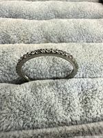 Front view of ring standing upright displaying full circle of stones