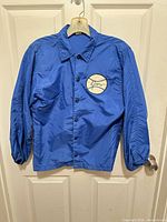 Front view of blue windbreaker with baseball name patch