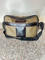Front view of Samsonite tan and black messenger bag with shoulder strap