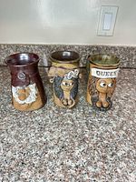 Front view of three mugs showing designs