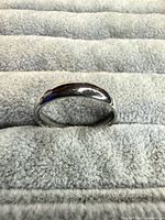 Front view of silver-tone domed band ring showing exterior finish