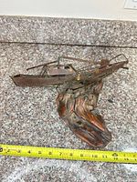 Full view of metal boat on wood base with measuring tape showing approx. 11 in. length