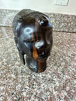 Front view of carved wooden African bust showing facial features