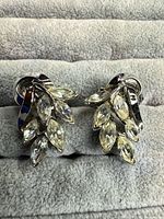 Front view of both clip-on earrings displaying leaf design and rhinestones