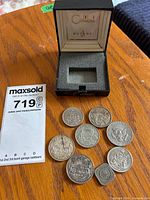 Eight coins and empty Colibri box overview