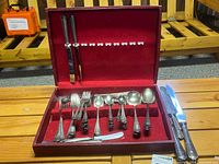 Open case showing majority of flatware pieces and fitted red velvet interior