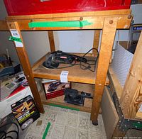 Front view of wooden rolling cart with two lower shelves and caster wheels