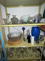 Three shelves showing entire assortment of glassware