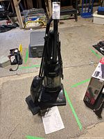 Front view of Eureka 4388 upright vacuum with detachable hand vacuum and manual on floor