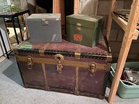 Front view showing Eveleigh trunk with brass hardware and two metal lock boxes on top