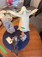All four figurines on table showing relative sizes