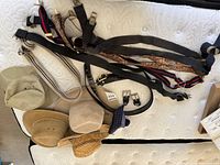 Overview of hats, suspenders and belts spread on mattress