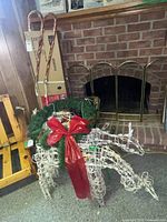 wireframe reindeer, boxed tree behind, candy cane lights leaning, wreath placed on reindeer