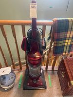 Front view of Hoover UH71213 vacuum with dust canister and attachments visible