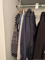 Six outerwear pieces hanging on closet rod