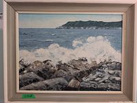 Frontal view of framed oil painting showing coastal scene and frame style