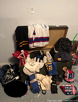 Overview of trunk open with jerseys, pads, gloves, socks, bags, skates and pucks