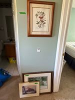 Wall-mounted framed Richardson print and two additional framed prints leaning below
