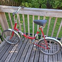 Full side view of red Unidal folding bicycle on deck