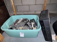 Overall view of RCA VCR beside plastic bin filled with assorted corded phones and cables